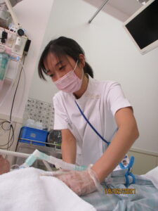人工呼吸器をつけた患者さんに呼吸のリハビリを行っている写真